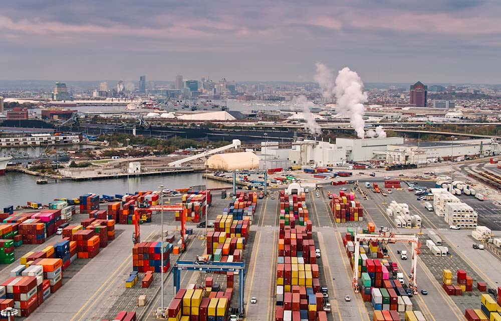 Aerial shot of the Port of Baltimore filled with shipping containers at sunset.