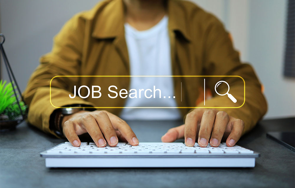 Person using a keyboard to search for job listings on the internet.