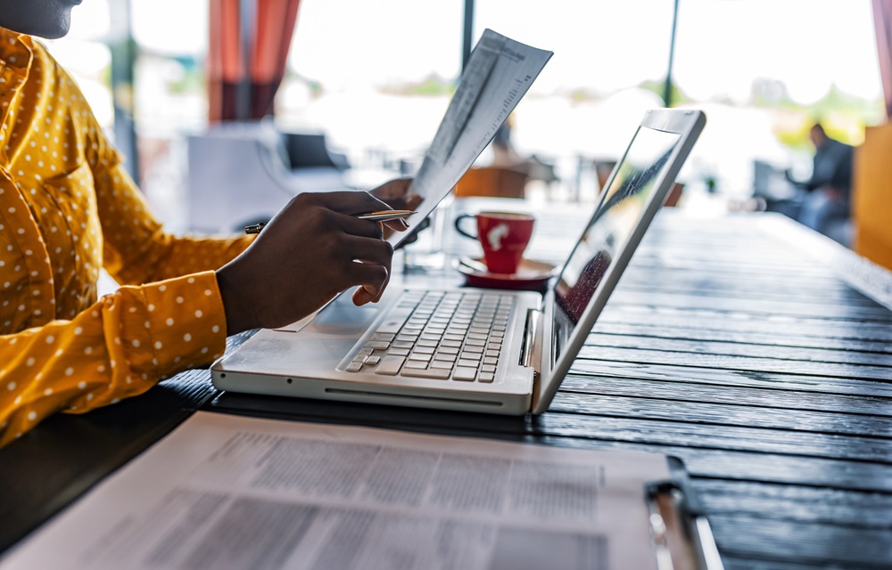 Examining papers and working on a laptop
