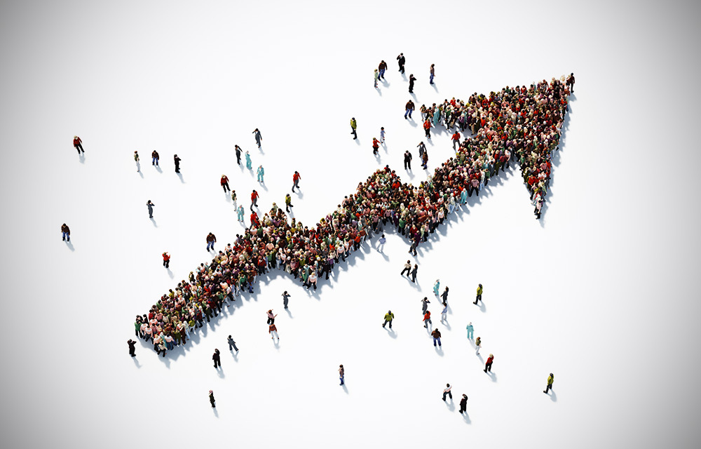 Human crowd forming the shape of an upward trending arrow.