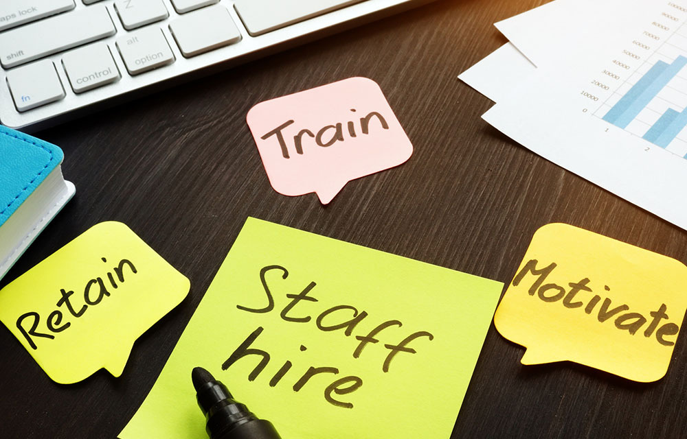 Staff hire, train, motivate and retain written on sticky notes.