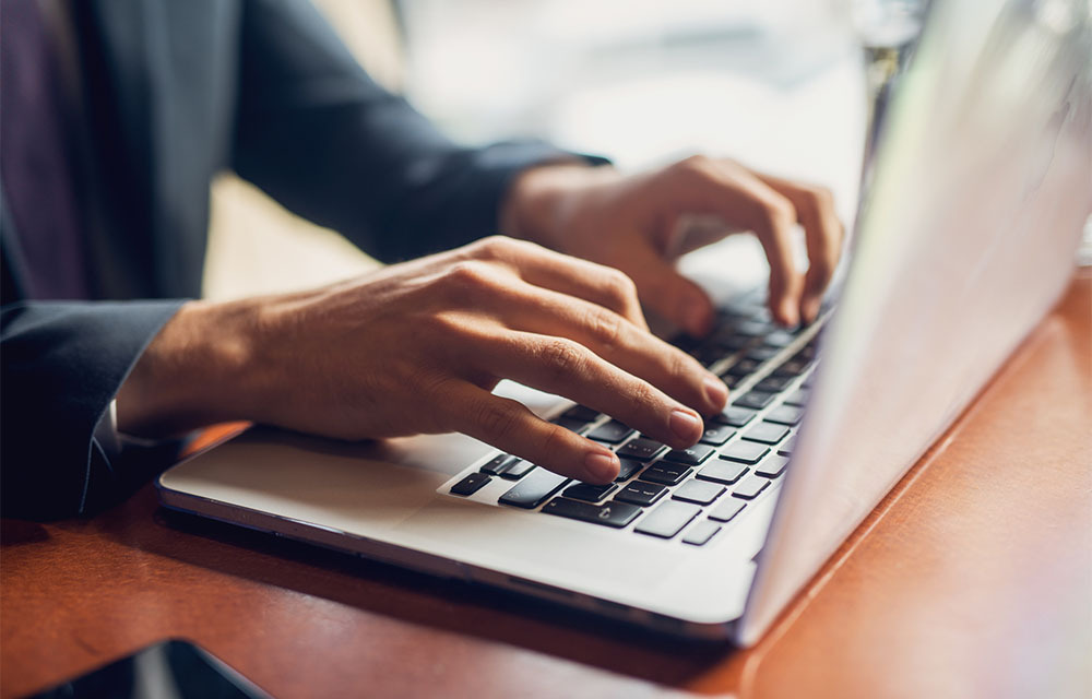 Close up of a person typing on a keyboard.