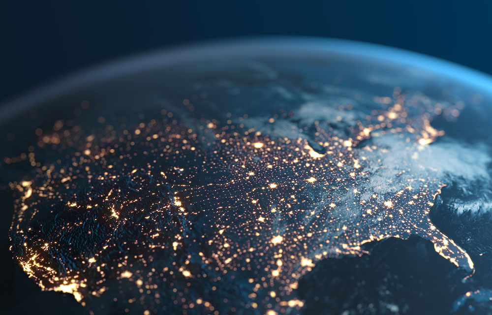 Overhead view of Earth focusing on the United States. There are lights heavily populated across the country representing different hotspots.