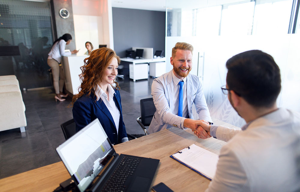Image of young couple talking to loan officer.