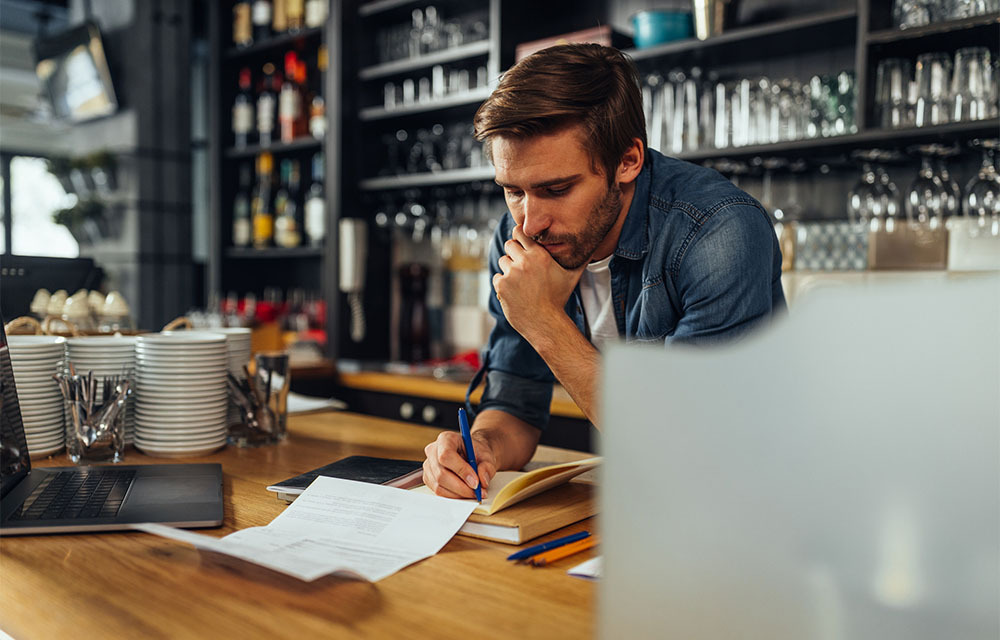 A concerned business owner pondering his restaurant's expenses.