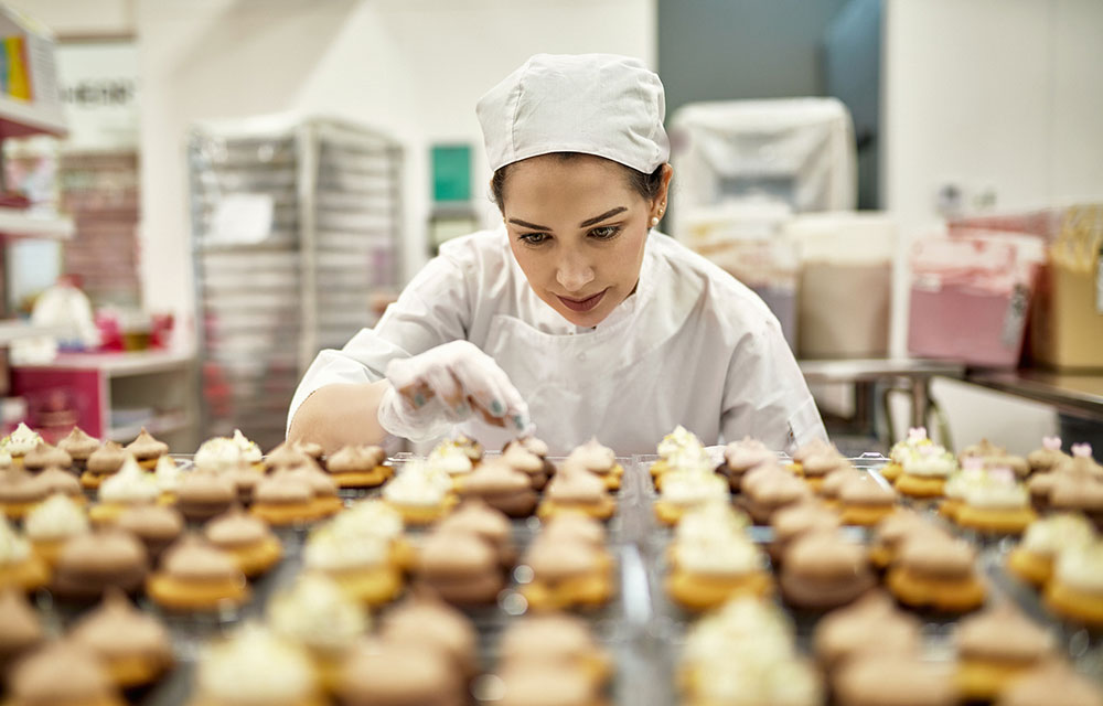 baker decorating cupcakes