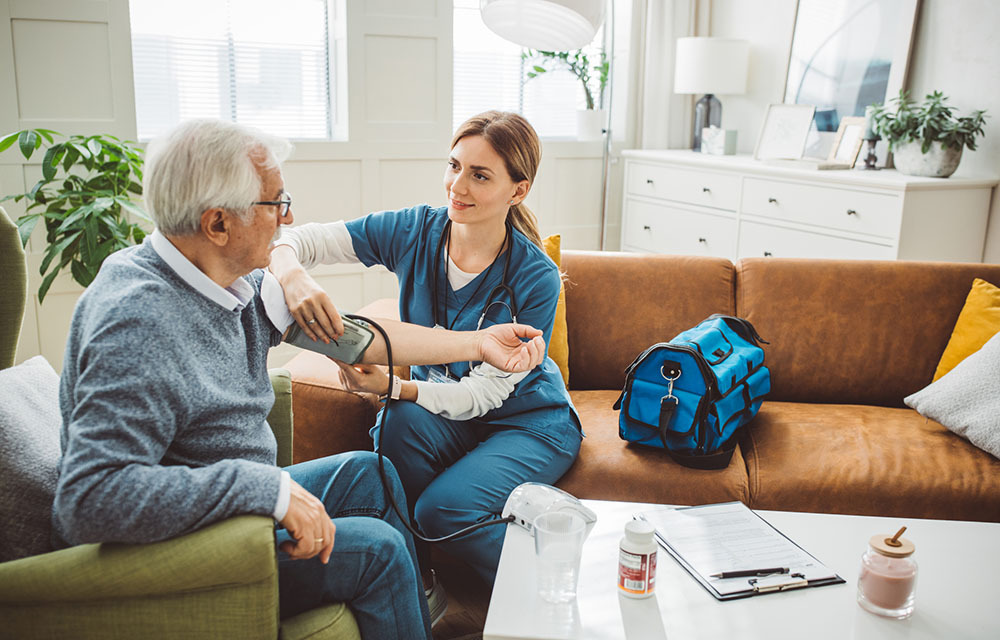 Home health nurse taking vitals of her patient.