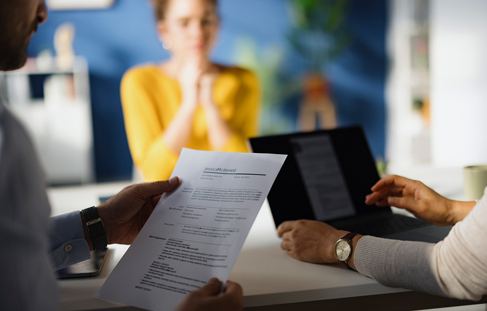 Interviewers discussing a candidate's resume and credentials with them.