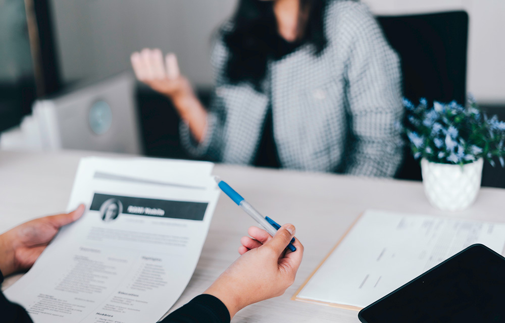 Hiring manager viewing a resume while they interview a candidate.