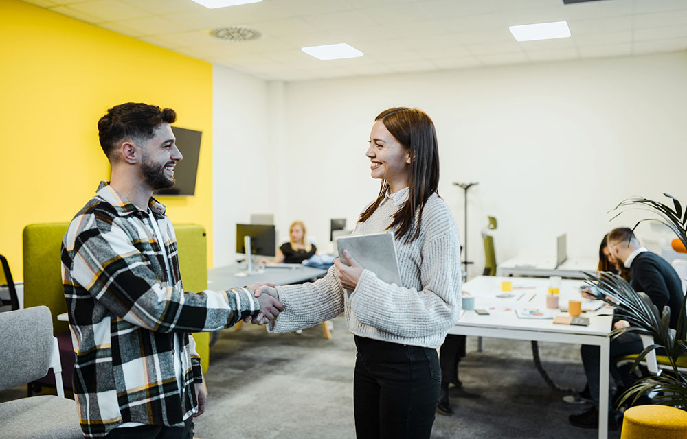 Male intern meeting a female superior and shaking hands