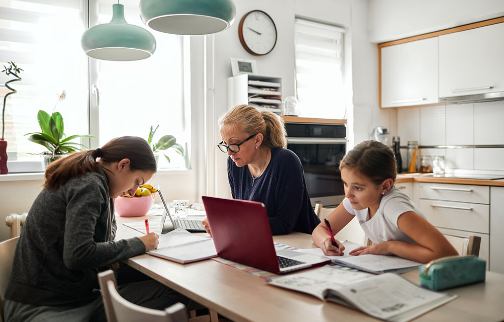 Mother helping her daughters with remote school work