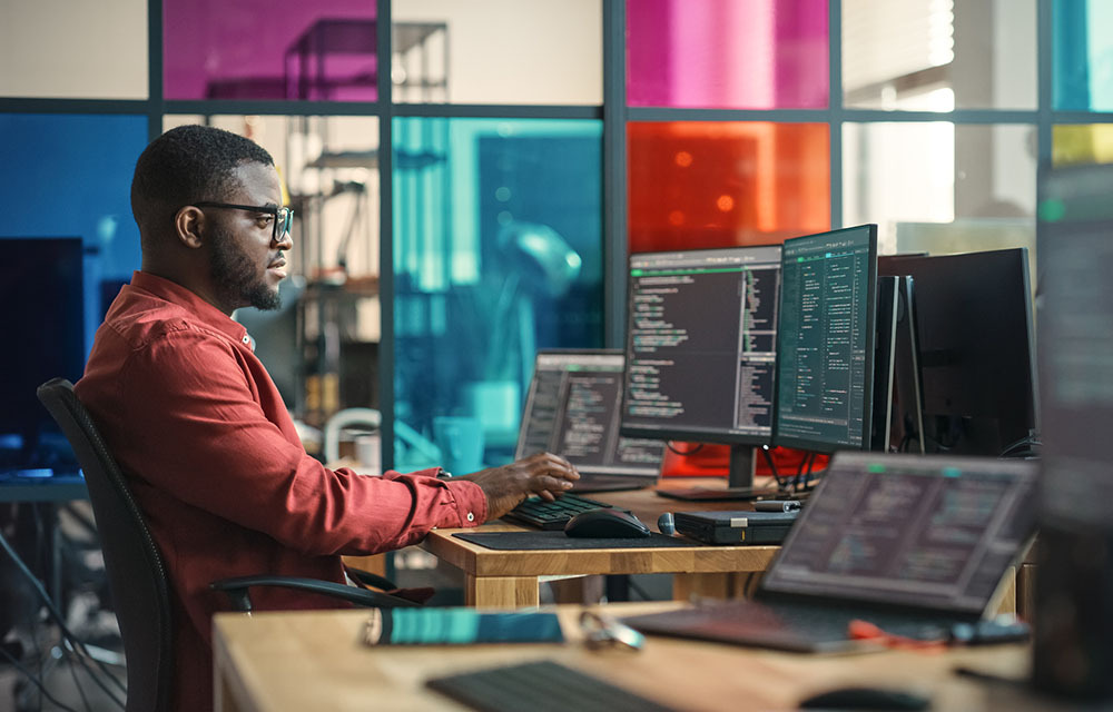 Software developer writing code in his office while using AI tools.