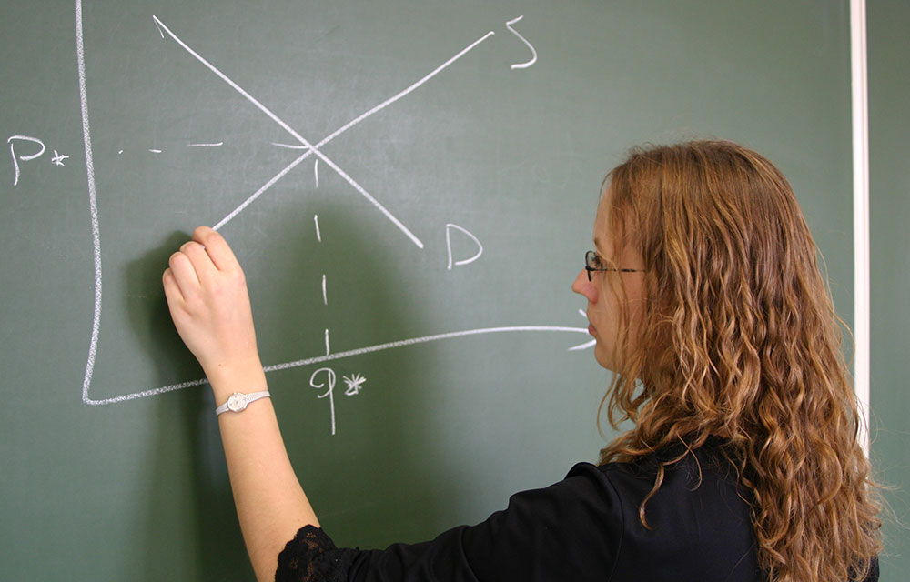 Teacher at a blackboard drawing a graph