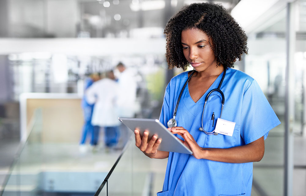 young medical professional woman looking up something on a tablet