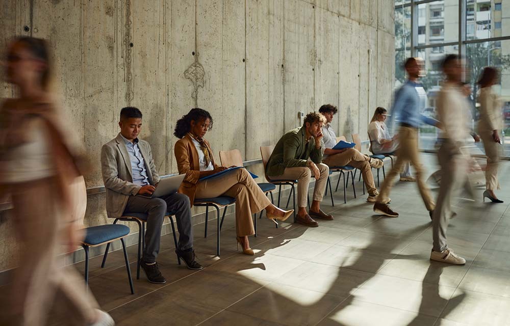 Group of people in business attire awaiting their name to be called for a job interview.