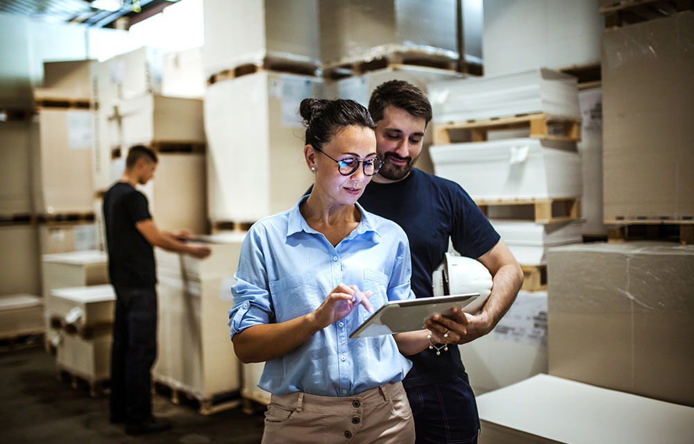 Warehouse supervisor walking and talking with senior manager