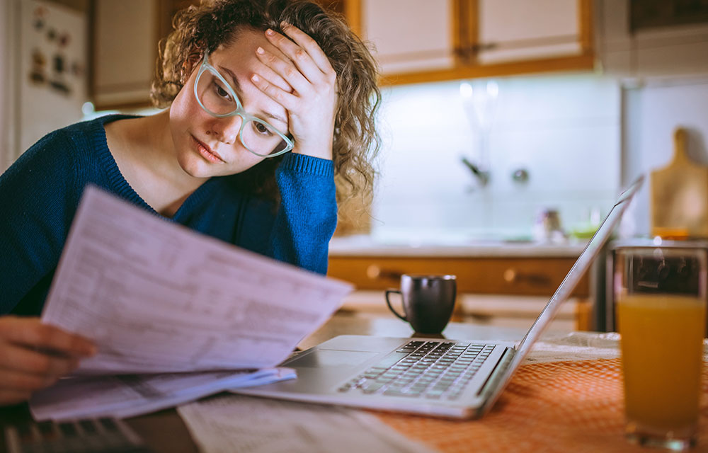 Woman in kitchen reviewing finances