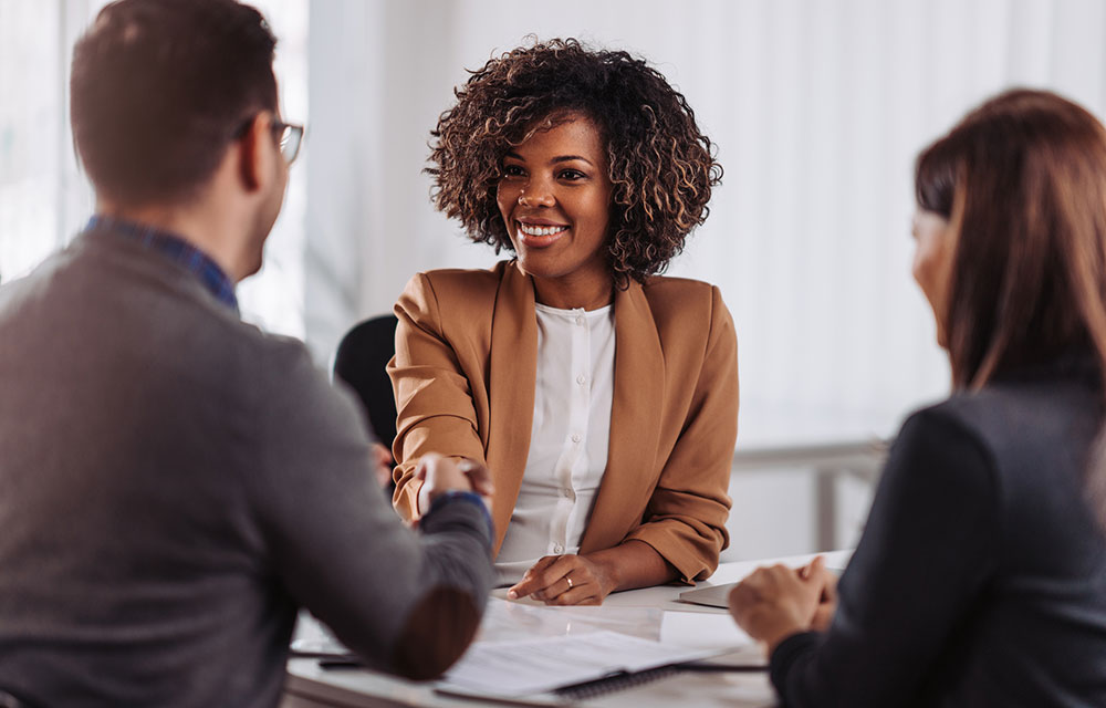 woman shaking hands with people in a meeting