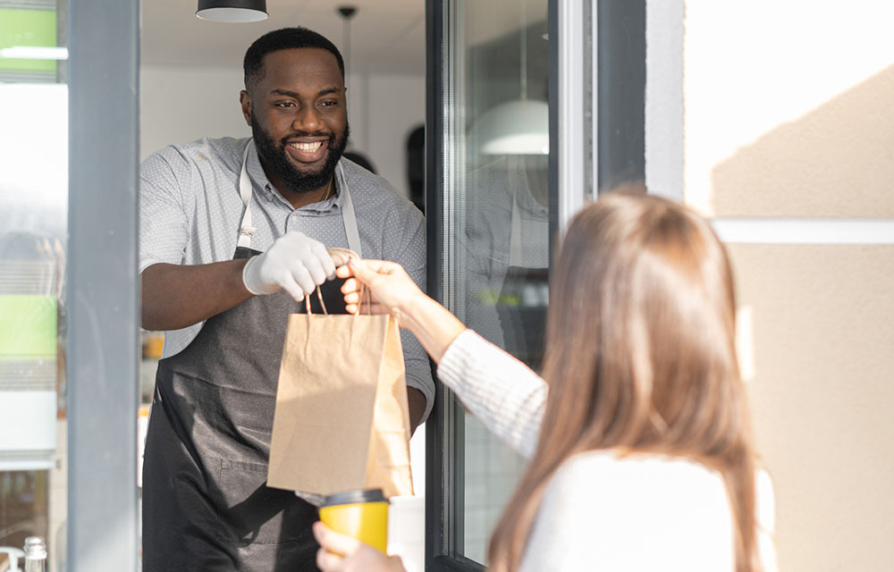 woman receiving takeout at a takeout window