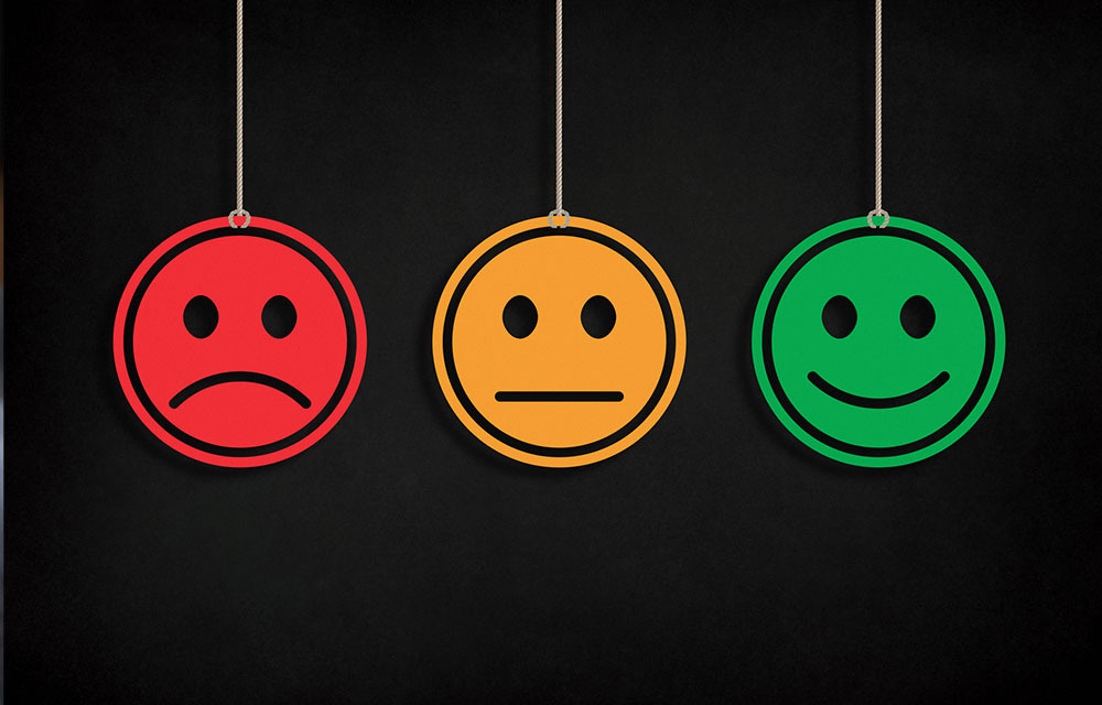 A happy, neutral, and sad smiley face hanging beside each other.
