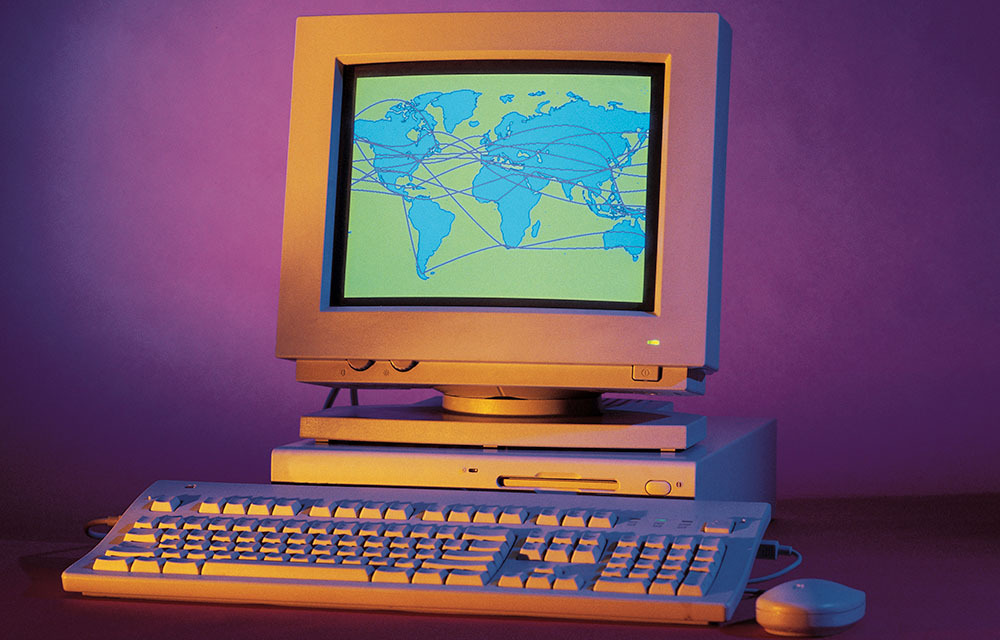 Desktop computer from late 90s or early 2000s with a graphic of a world map on the monitor