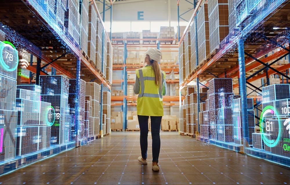 Warehouse worker in a safety vest walks through storage area with a technology overlay showing data about all of the containers.