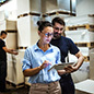 Warehouse supervisor walking and talking with senior manager