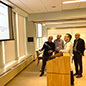 Four men discuss a presentation at Core Week