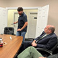 Tom Barkin watches a man demonstrate a device
