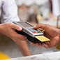 Close up of a person's hand swiping a credit card.